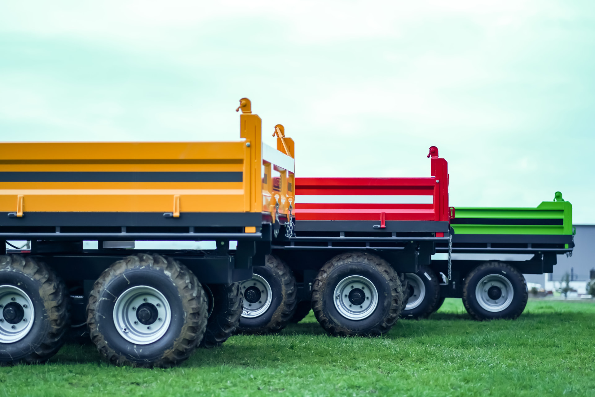 Close view of Maxi tip trailer decks and tandem wheels on grass