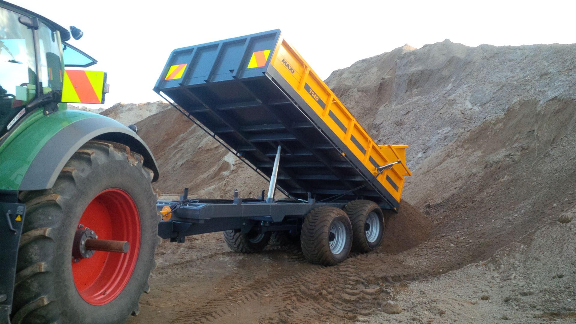 Maxi T140 tip trailer tipping soil at a stockpile behind a Fendt tractor