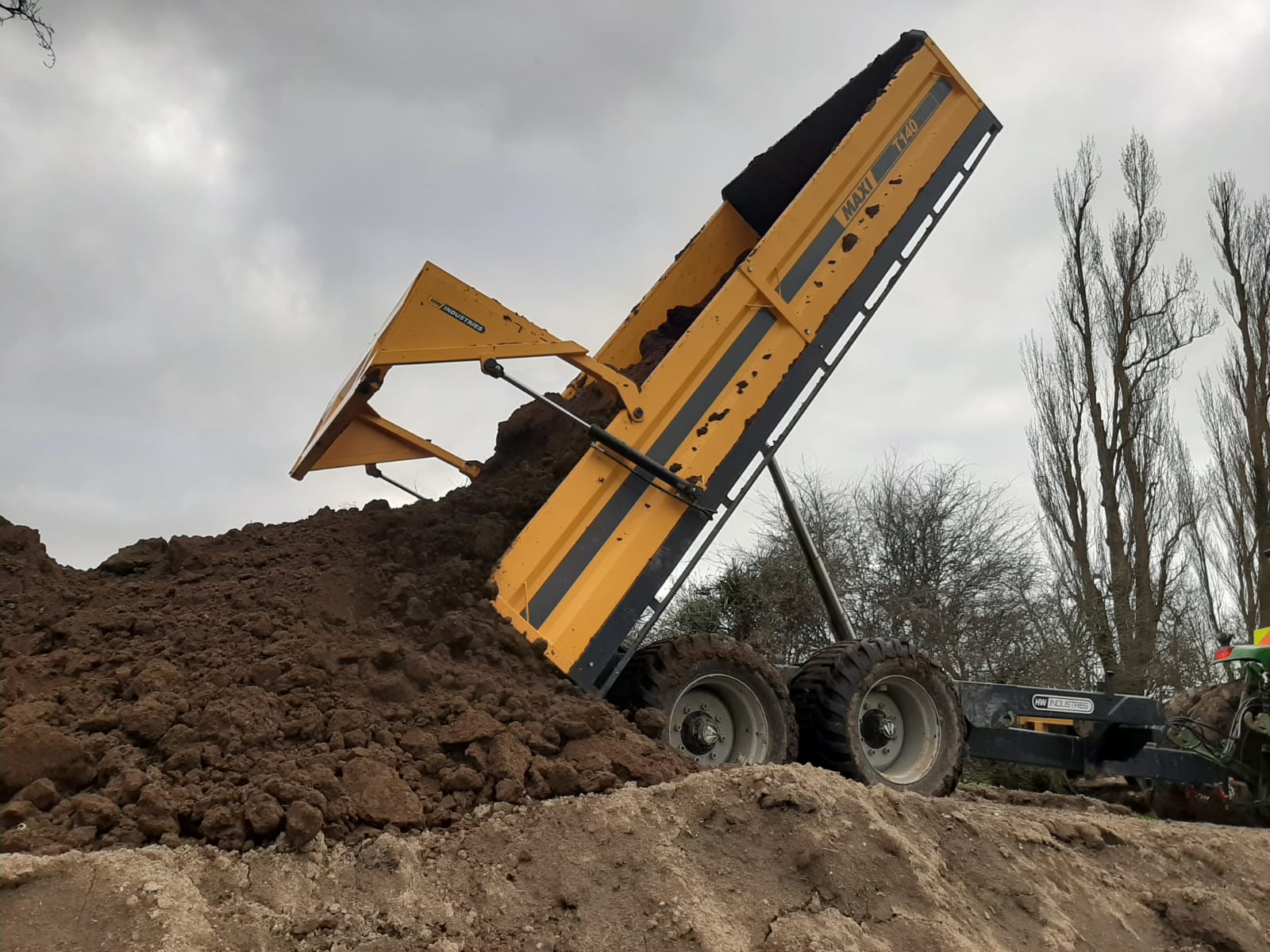 Maxi T140 trailer tipping a heavy load of earth on the farm